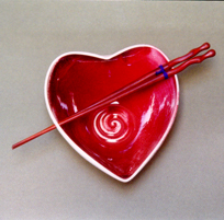 Tazón rojo en forma de corazón con palillos palisa