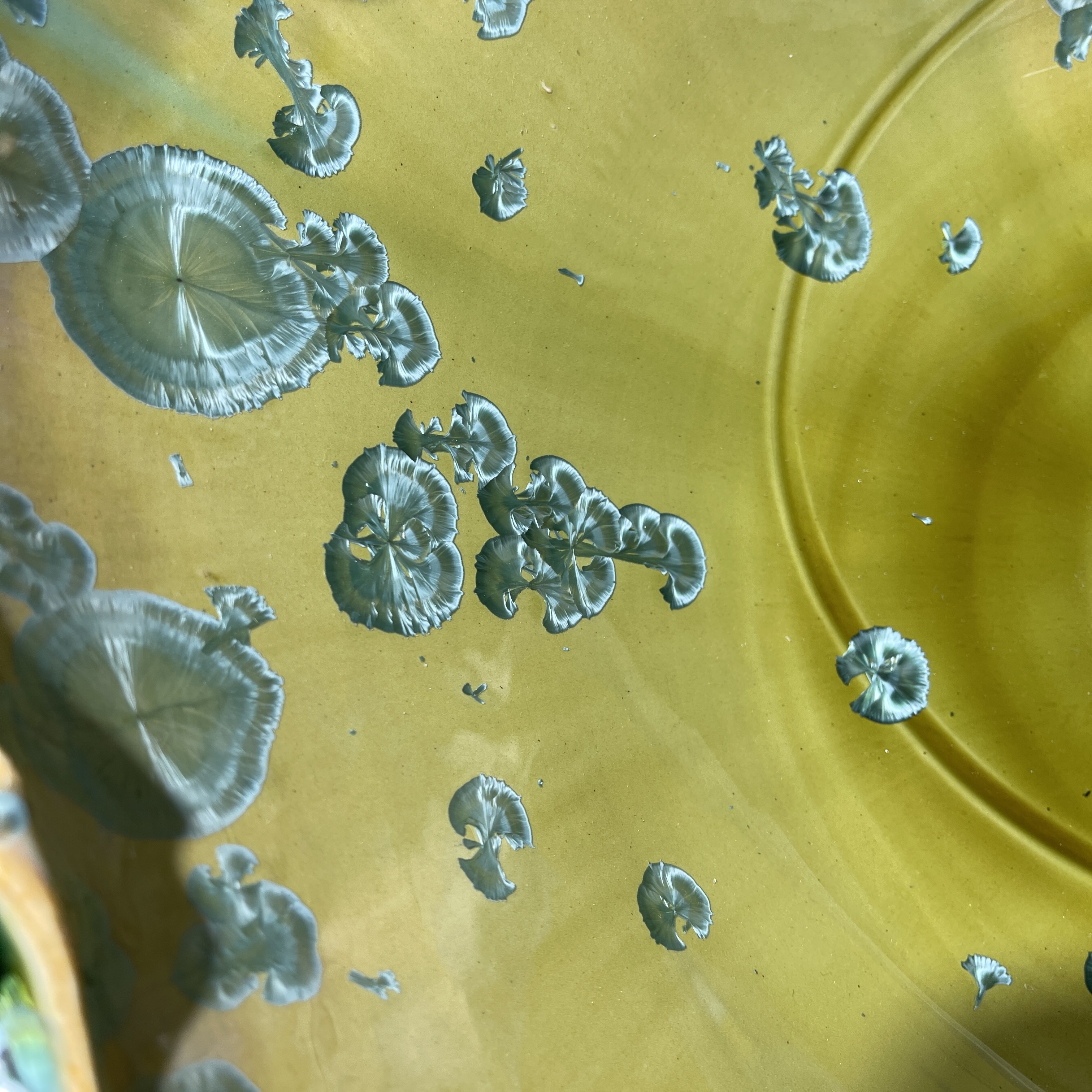 Lavabo con forma ovoide en cristal verde con detalles esculturales arremolinados
