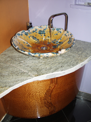 Artistic shallow bloom shape sink in a nickle crystalline glaze as installed in a home close up